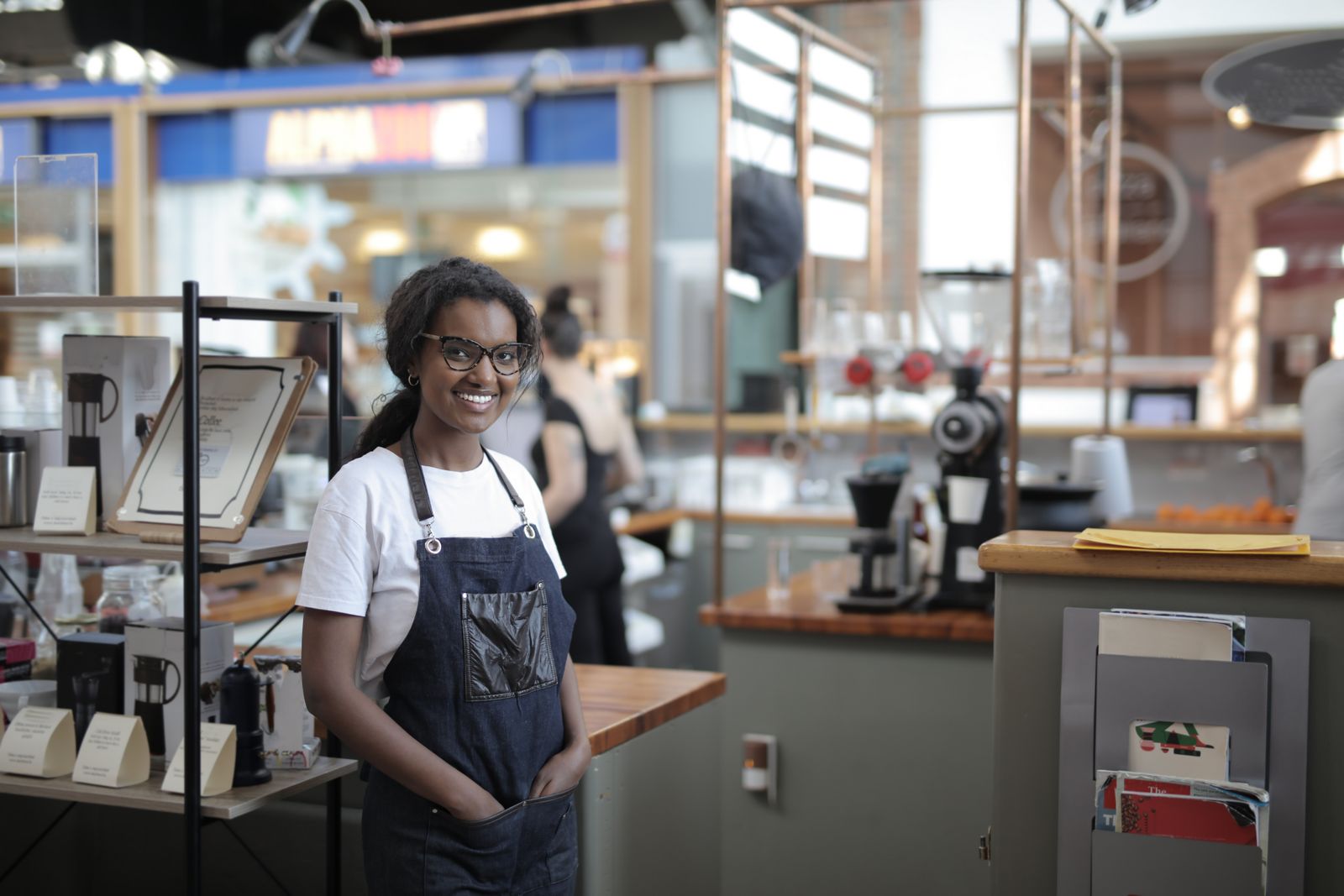 A smiling owner standing in her café